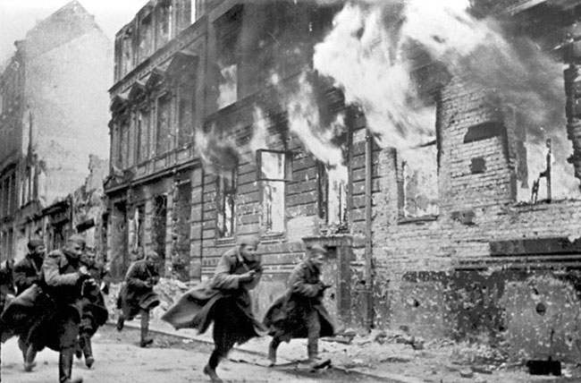 Советские солдаты пробегают по улице горящего Берлина, 1945 г. Автор съемки: Темин В.А.