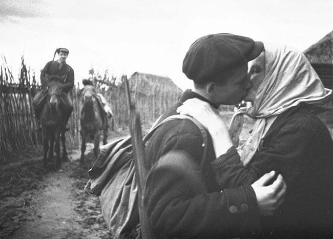 Колхозница одного из сел отправляет своего сына в партизанский отряд. Ленинградская область, 1942 г. Автор съемки: Трахман М. А.