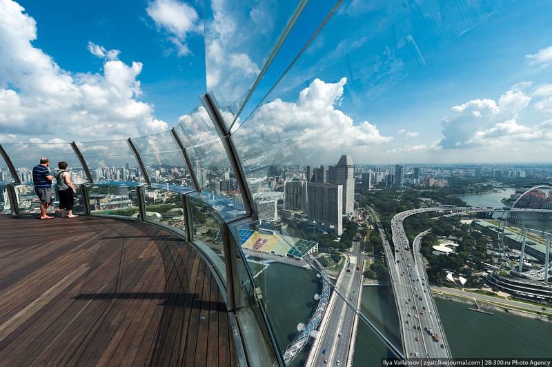 Отель Marina Bay Sands, бассейн под облаками Площадка огорожена стеклом, чтобы туристы не выпали. Кстати, отсюда открывается лучший вид на трассу Формулы-1. Но попасть сюда во время гонки почти невозможно. Террасу традиционно выкупают русские олигархи и устраивают тут пьянку.