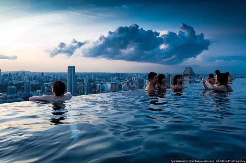 Отель Marina Bay Sands, бассейн под облаками Кажется, что за краем бассейна пропасть. На самом деле там ниже есть выступ технический, по которому бегает прислуга. Поэтому даже если вы свалитесь, то далеко не улетите.